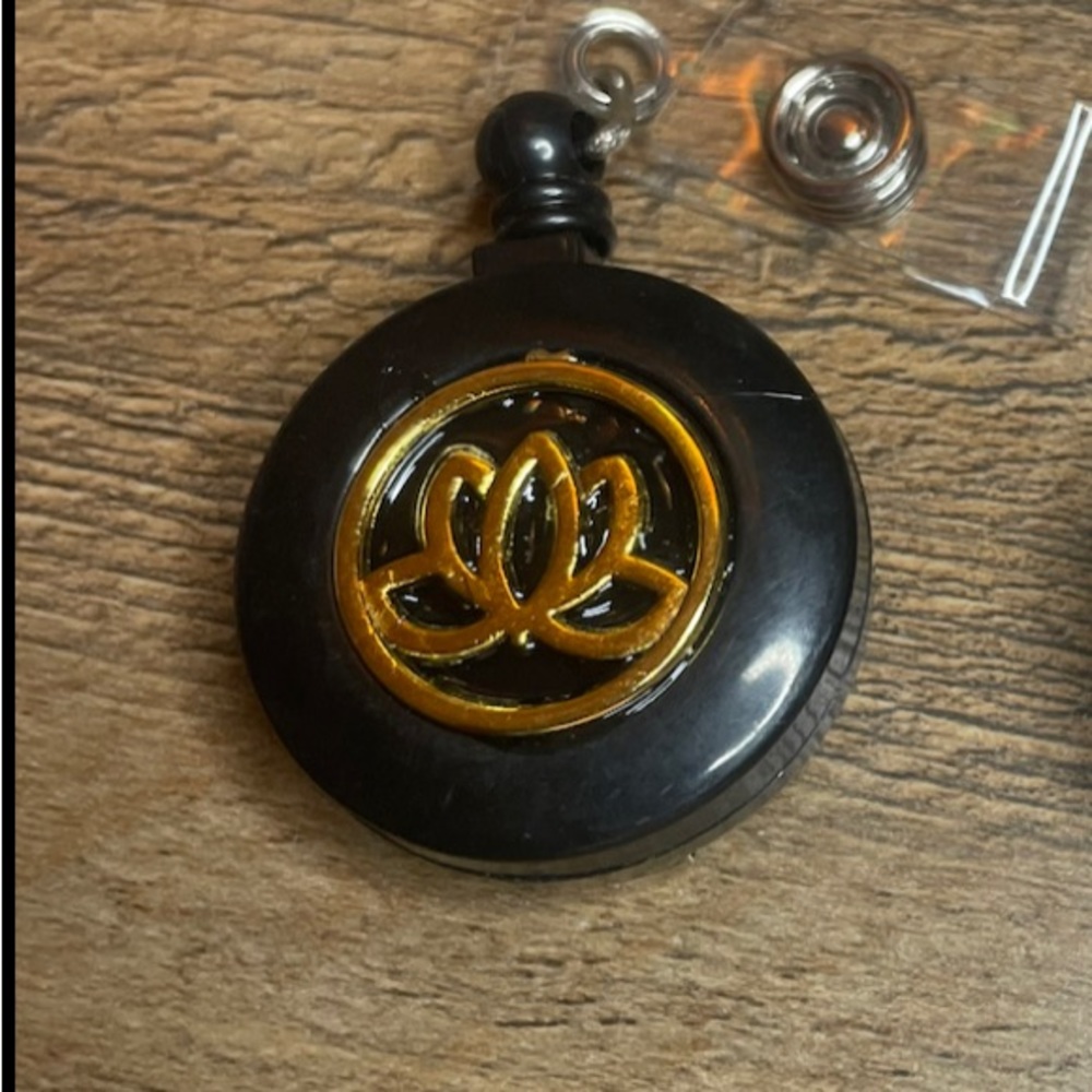 Self retracting badge holder with lotus flower charm